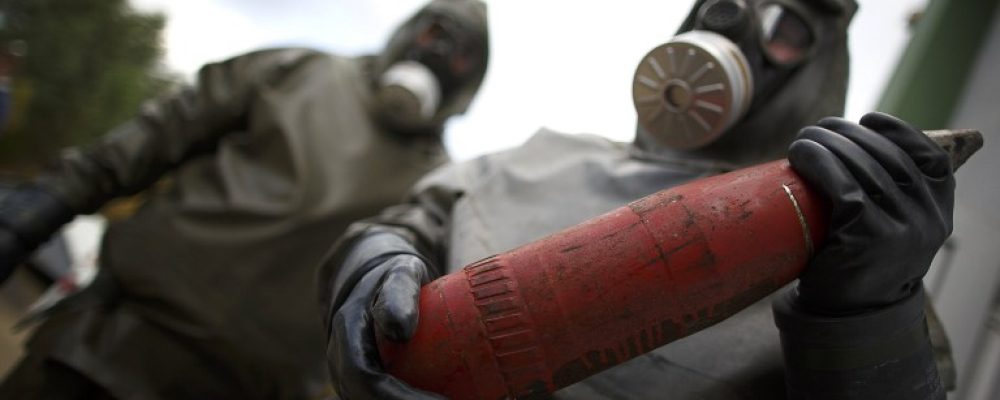 (FILES) This photo taken on October 30, 2013, shows employees in protective gear holding a dummy grenade during a demonstration at a chemical weapons disposal facility of GEKA (Gesellschaft zur Entsorgung von chemischen Kampfstoffen und Ruestungsaltlasten) in Munster, northern Germany. Syria has surrendered or destroyed nearly a third of its chemical arsenal but remains behind on its international obligations, the head of the disarmament mission told the world's chemical watchdog on March 4, 2014. Syria has already missed several target dates to hand over or destroy its arsenal before a June 30 deadline and the United Nations-Organisation for the Prohibition of Chemical Weapons (OPCW) mission called on Damascus to move faster. AFP PHOTO / PHILIPP GUELLAND