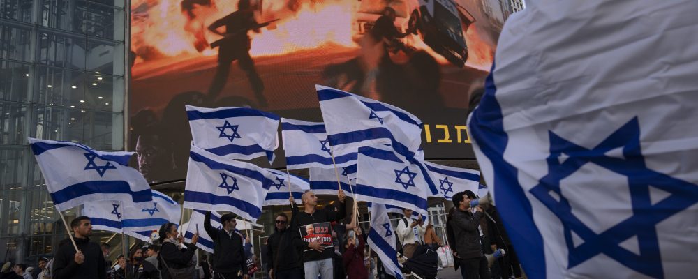 Right wing activists wave Israeli flags during a protest against Israel's Prime Minister Naftali Bennett, following a recent wave of violence, in Tel Aviv, Israel, Wednesday, March 30, 2022. Three deadly attacks in Israel in a week are raising questions over Israel's approach to its conflict with the Palestinians, after years of efforts to sideline the issue and focus instead on other regional priorities.(AP Photo/Oded Balilty)