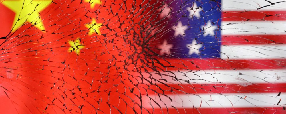 U.S. and Chinese flags are seen through broken glass in this illustration taken, January 30, 2023. REUTERS/Dado Ruvic/Illustration