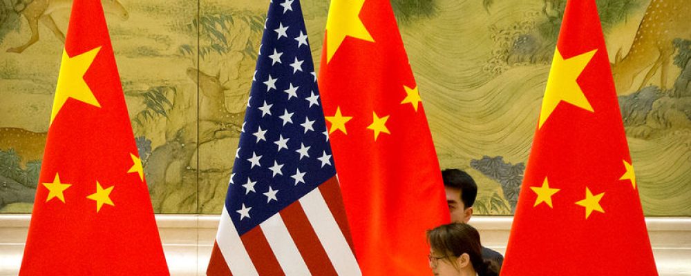 FILE PHOTO: Chinese staffers adjust U.S. and Chinese flags before the opening session of trade negotiations between U.S. and Chinese trade representatives at the Diaoyutai State Guesthouse in Beijing, Thursday, Feb. 14, 2019. Mark Schiefelbein/Pool via REUTERS